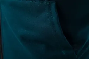 Vue macro du tissu respirant bleu sarcelle et des coutures sur un gilet pour homme.