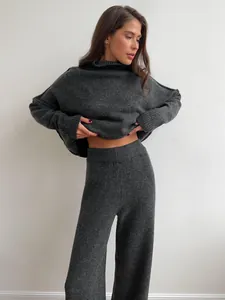 Close-up of a cozy dark grey knitted turtleneck sweater and wide-leg trousers set