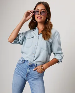 Detail view of a premium light blue denim shirt featuring classic double front pockets