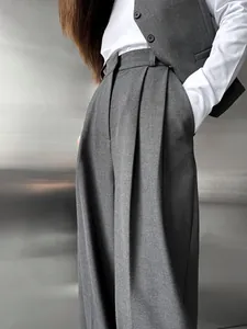 Gros plan d'un pantalon large gris élégant avec un drapé de qualité et des plis.