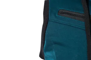 Détail d'un gilet de sport bleu sarcelle montrant la fermeture éclair et la bordure côtelée.
