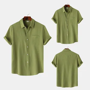 Vista detallada de camisa de manga corta verde oliva para hombre con textura y bolsillo.