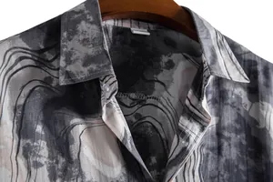 Close-up detail of men's casual shirt featuring an abstract gray wavy pattern and lapel collar