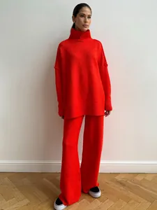 Detailed view of women's orange-red oversized turtleneck knit set with wide-leg pants
