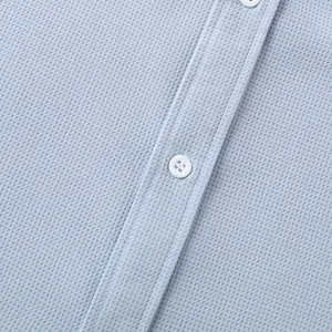Detailed macro view of light blue waffle texture fabric on a men's casual shirt