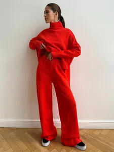 Full-body view of a woman wearing a red turtleneck sweater and wide-leg knit pants.