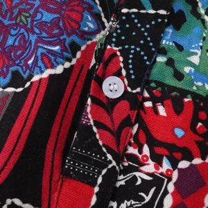Macro view of the colorful tribal print and white button on men's Hawaii shirt