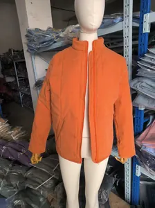 Oranges Baumwolljacke mit Stehkragen auf einer Schaufensterpuppe im Lagerhaus.