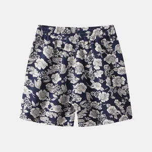 Detailed view of men's floral beach shorts with navy and white botanical patterns.