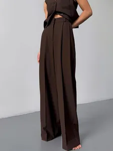 Vue détaillée du pantalon de costume marron foncé à jambes larges avec un drapé élégant.