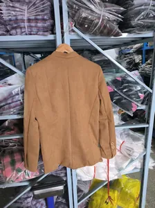 Detail view of the back of a casual men's suede suit jacket in tan brown color