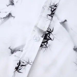 Détail d'une chemise homme à manches courtes avec motif bambou à l'encre noire sur blanc