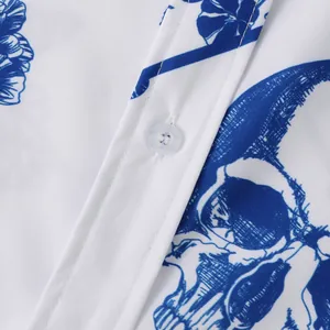 Close-up of white Halloween shirt with blue skull floral print and white button detail.