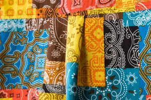 Macro detail of the colorful patchwork paisley pattern on a cotton linen shirt