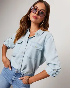 Detail shot of light blue denim shirt with double chest pockets on casual model