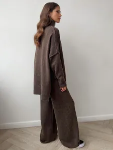 Side view of woman in cozy brown oversized turtleneck sweater and knit wide-leg pants