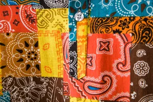 Close-up detail of colorful patchwork paisley pattern on breathable cotton linen shirt