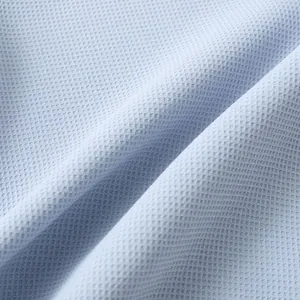 Close-up of breathable light blue waffle weave fabric texture for men's casual shirt