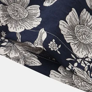 Detail shot of navy blue cotton linen fabric with white floral print for men's shorts.