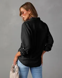 Back view of a black long-sleeved denim shirt for women with buttoned sleeve detail