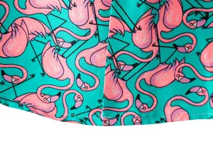 Macro detail of pink flamingo print on teal men's short sleeve shirt fabric texture