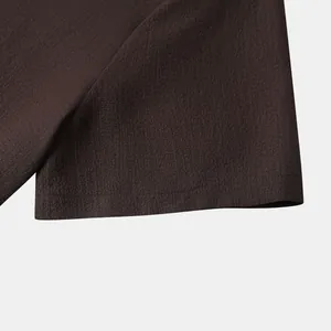 Detailed macro view of dark brown crinkle texture fabric and hem on a men's shirt