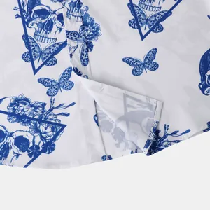 Detail of white short-sleeved shirt with blue skull and butterfly prints for men.