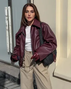 Gedetailleerde weergave van een trendy bordeauxrode oversized kunstleren motorjas voor dames.