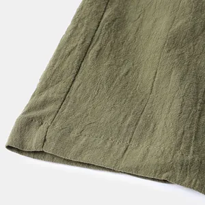 Gros plan sur un short en lin vert olive montrant la texture du tissu et les coutures
