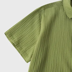 Detalle de cerca de una camisa de hombre verde oliva de manga corta con tela rugosa.