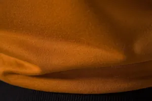 Gros plan macro du tissu en maille respirante et de l'ourlet côtelé d'un gilet de sport.