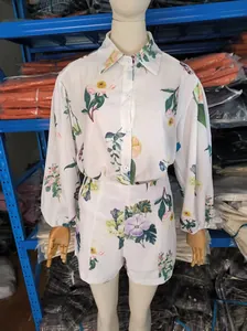 Detail of a white floral print linen shirt and high-waist shorts set on a mannequin.