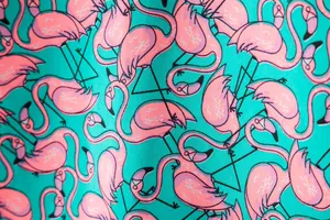 Close-up detail of the pink flamingo and black geometric print on turquoise fabric