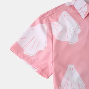 Dettaglio di una camicia estiva rosa a maniche corte con una simpatica fantasia a fantasmi bianchi.
