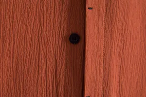 Macro view showing the detailed fabric texture and button on this men's rust orange shirt