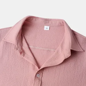 Close-up of pink men's short sleeve shirt collar showing textured fabric and size M label