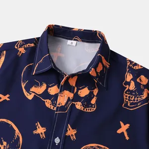 Close-up of a Halloween men's shirt collar featuring orange skull prints on navy blue