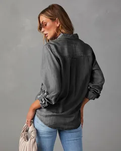 Back view of a stylish washed gray denim shirt for women with long sleeves and pleated detail.