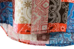 Macro view of the double-needle hem and paisley patchwork pattern on a linen shirt.