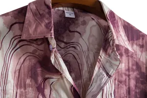 Detailed close-up of men's casual shirt lapel featuring burgundy marble print pattern