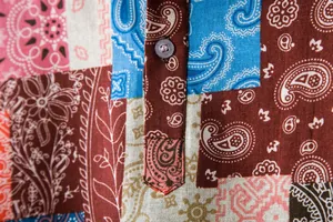 Close-up of men's linen shirt showcasing intricate paisley patchwork pattern and fabric texture.