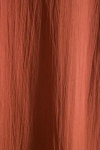 Macro view of breathable burnt orange crepe fabric texture for summer men's shirt