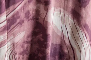 Detailed macro view of purple marbled fabric with dark wavy stripes on a men's casual shirt