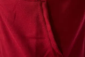 Gros plan du tissu en maille rouge montrant la double couture d'un gilet de sport homme
