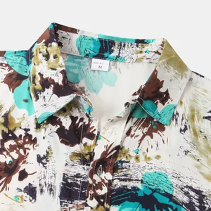 Close-up of Hawaiian print shirt collar with abstract teal and brown patterns.