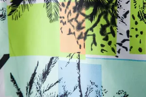 Detailed macro view of vibrant Hawaiian tropical palm tree print on men's summer shirt fabric.