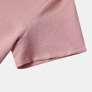 Close-up detail of the breathable pink textured fabric on a men's short-sleeved shirt