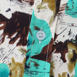 Macro detail of a Hawaiian print men's shirt showing the button and fabric texture