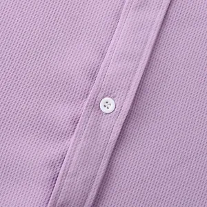 Close-up of purple shirt with waffle texture and white button detail