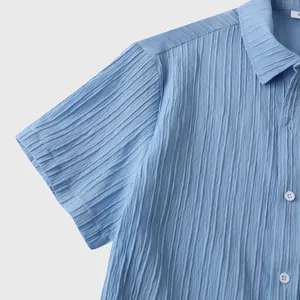 Detalle de cerca de camisa azul de manga corta que muestra la textura de tela plisada